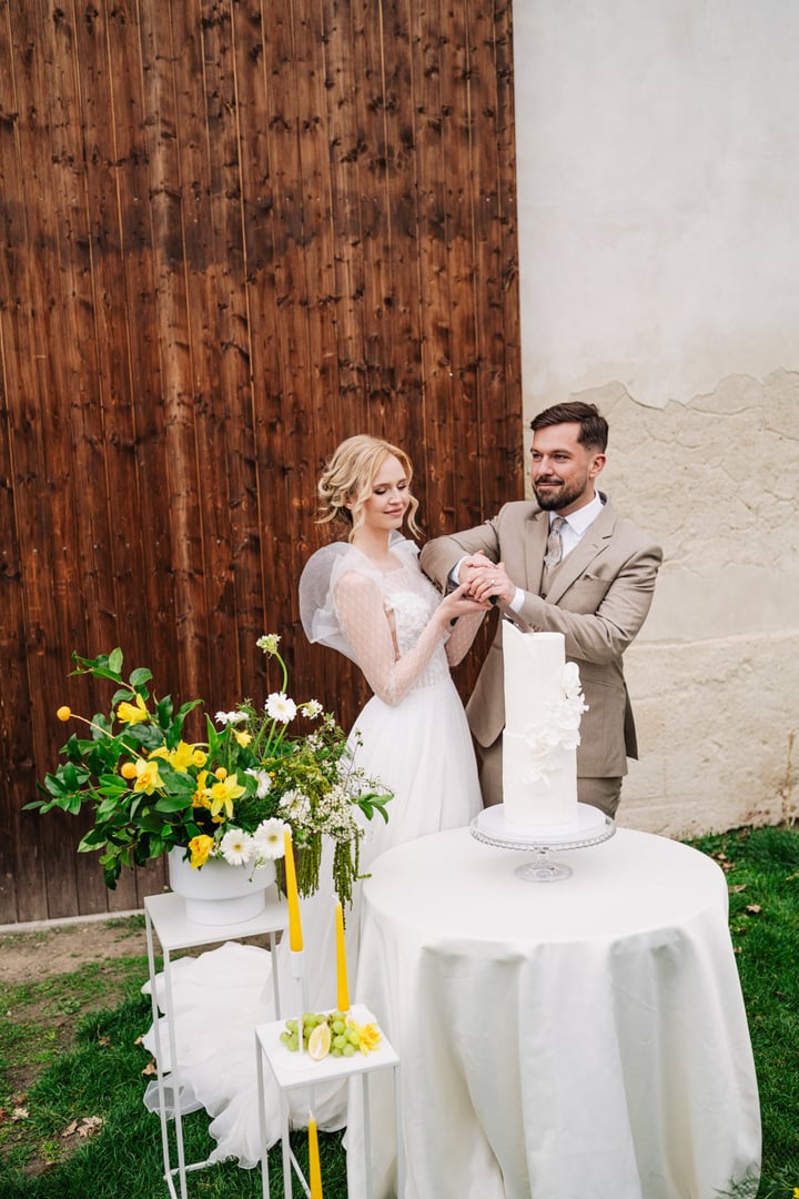 Nevěsta a ženich společně krájí dort